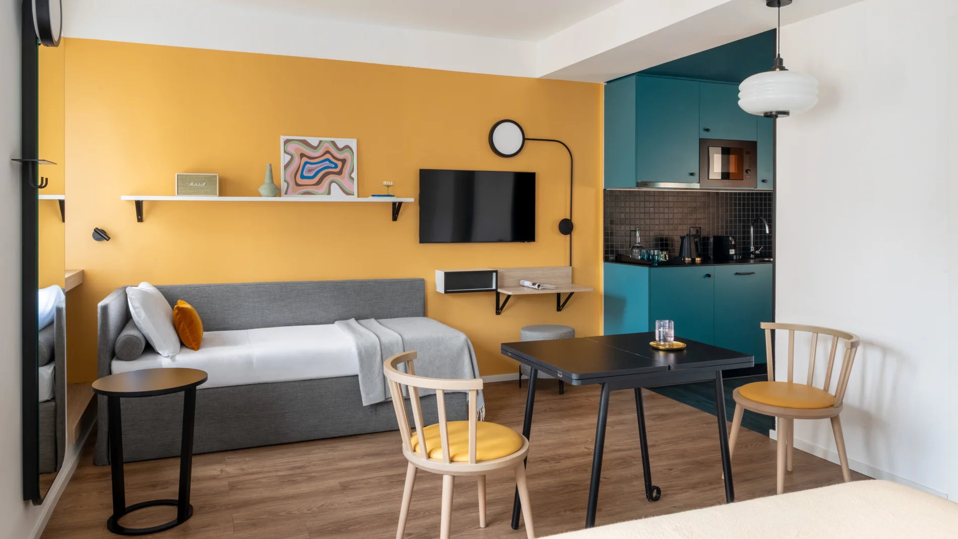 Studio with sofa bed, turquoise kitchen, table and yellow wall for smart stays - Aparthotel Colombo, BZAR hotels in Rome