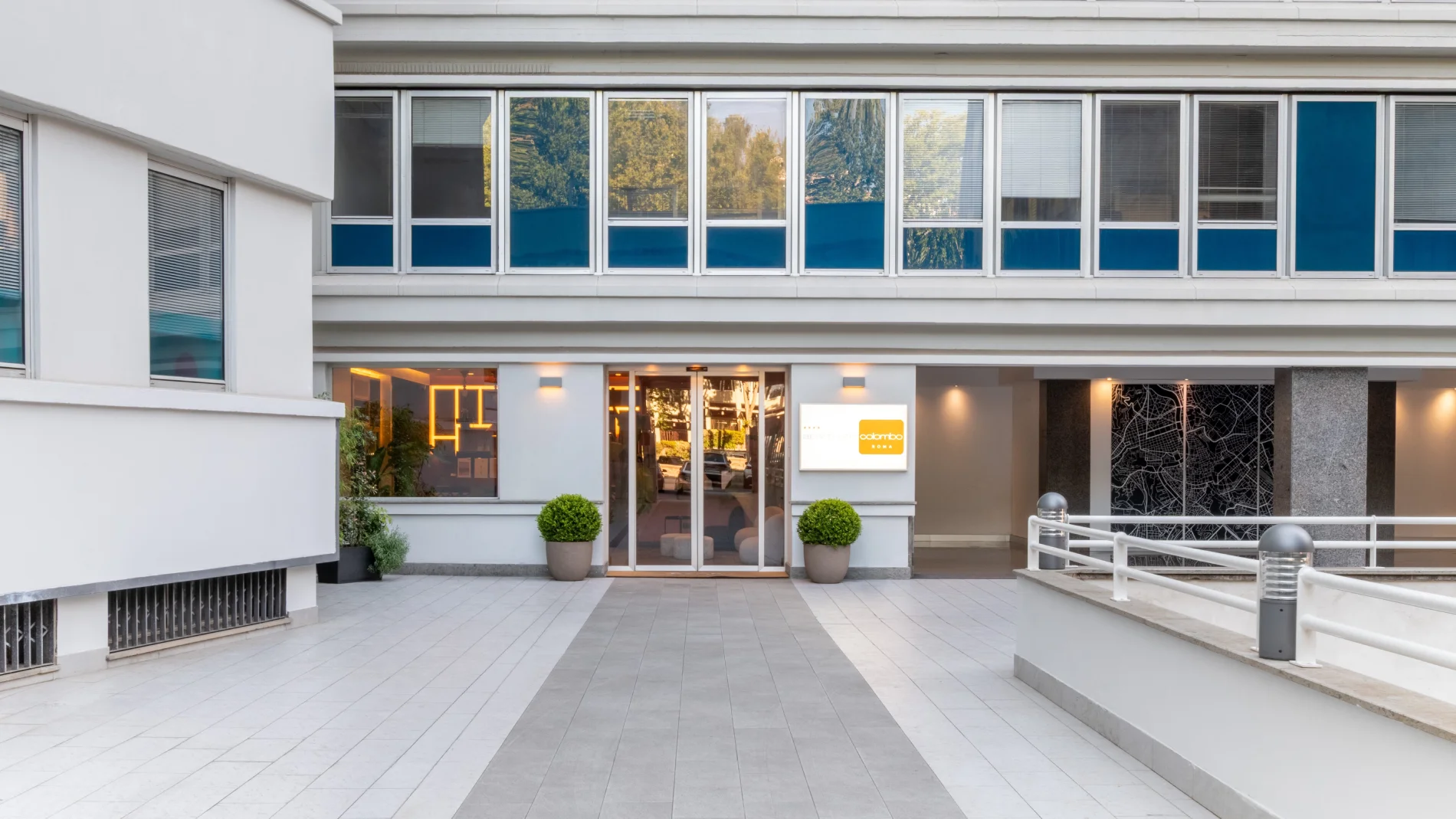 Hotel exterior entrance with modern facade, glass doors and urban courtyard access - Aparthotel Colombo, BZAR hotels in Rome