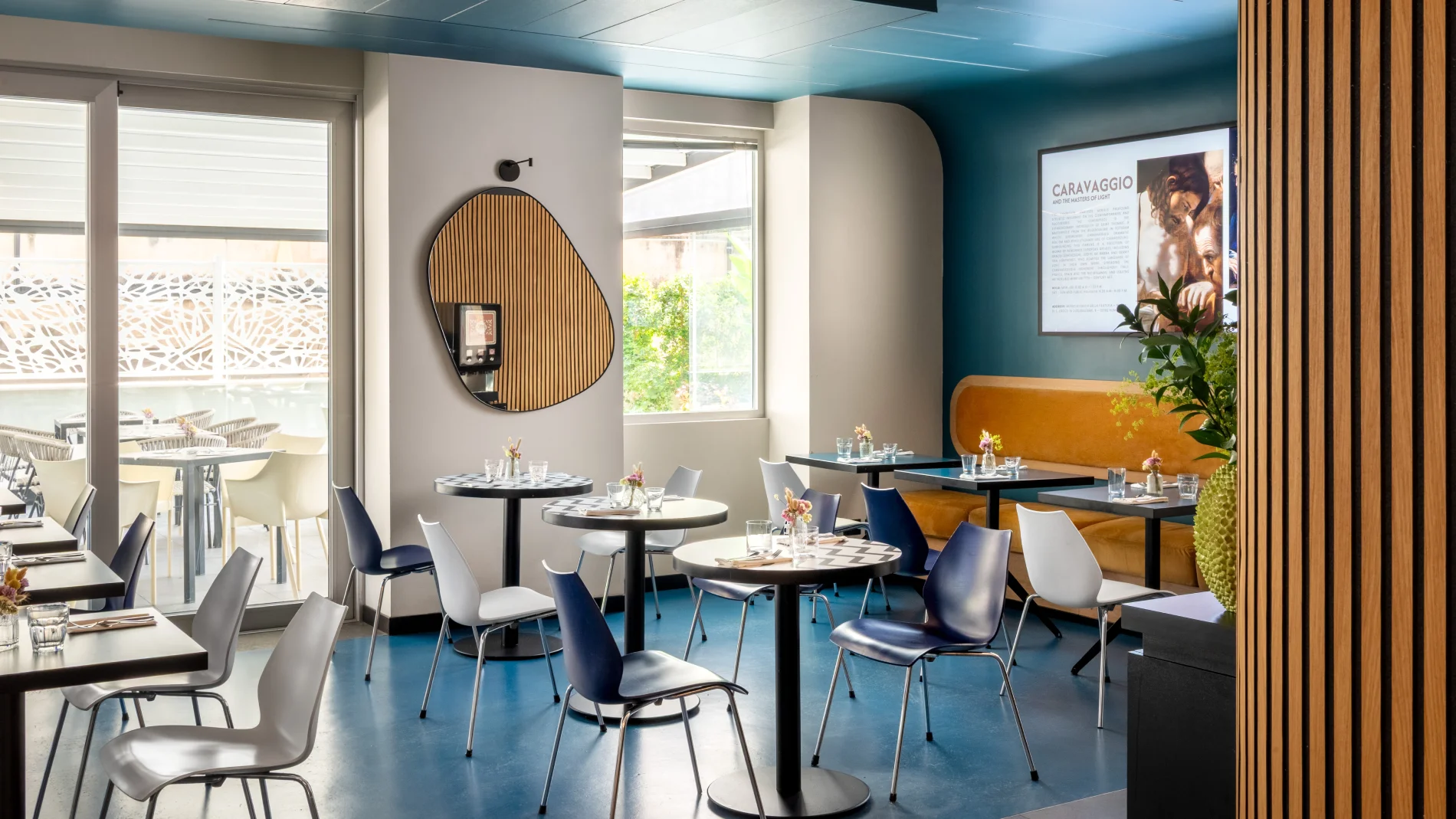Design breakfast room with set tables, blue walls and access to the green terrace - Aparthotel Colombo, BZAR hotels in Rome