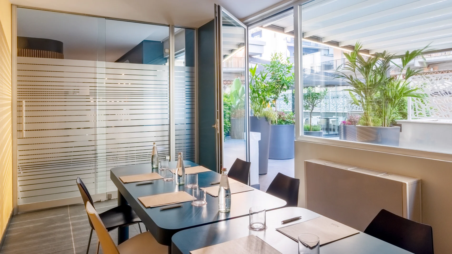 Meeting room with equipped table, glass walls and access to the green patio for events - Aparthotel Colombo, BZAR hotels in Rome