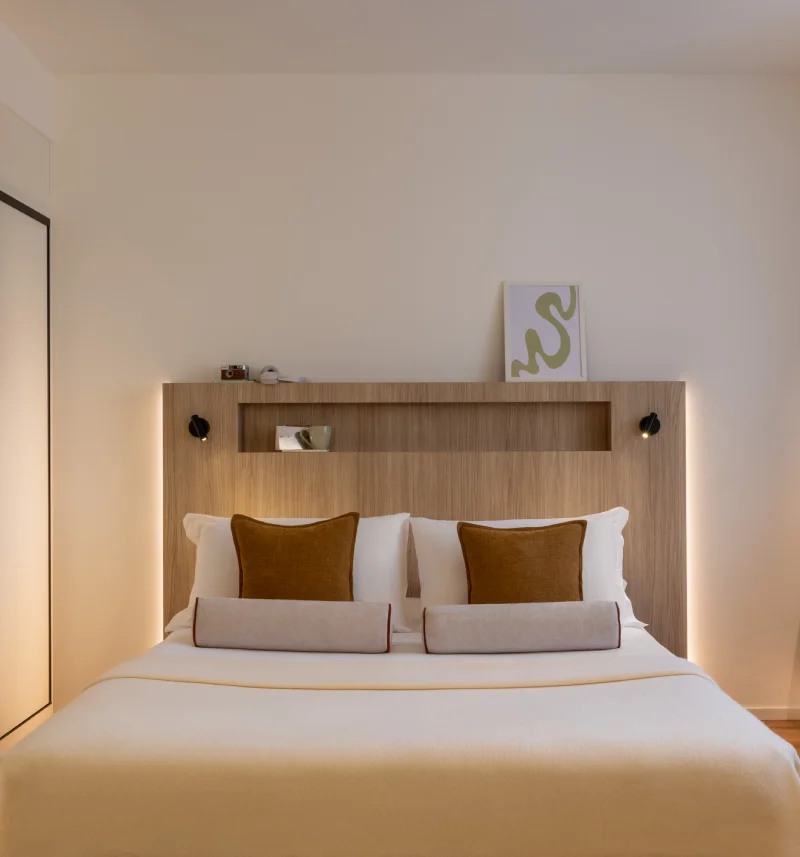 Elegant double bed with wood headboard, black wall lights and mustard cushions - Aparthotel Colombo, BZAR hotels in Rome