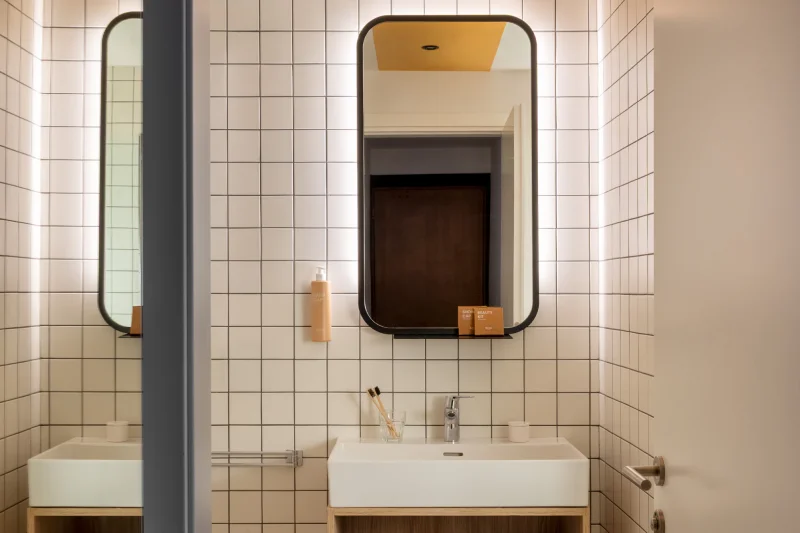 Modern bathroom with white sink, backlit mirror and elegant geometric tiles - Aparthotel Colombo, BZAR hotels in Rome
